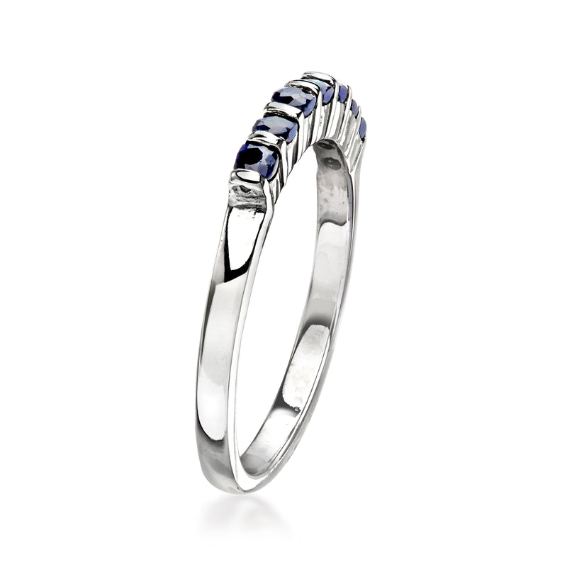 White gold band with row of dark blue sapphire gemstones, curved side view