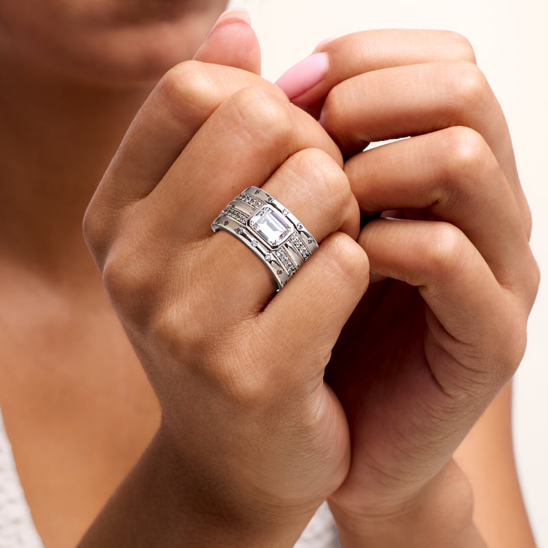Rhodium-plated CZ statement ring worn on finger, rectangular center stone