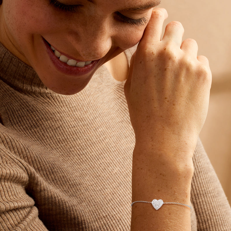 Sterling silver bracelet with small heart charm featuring crystal-like stones