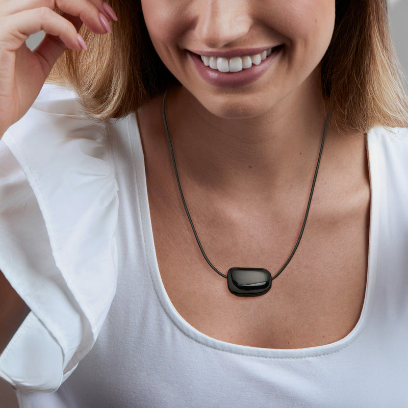 Black onyx-style bead pendant necklace with adjustable leather cord worn with casual top.