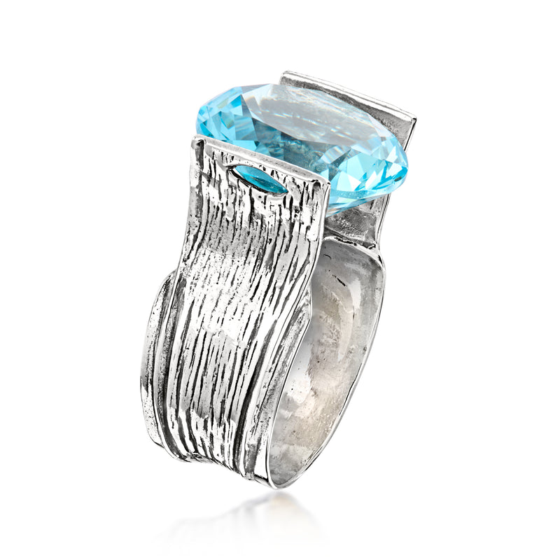 Sterling silver ring side view with simulated blue topaz held in prong setting