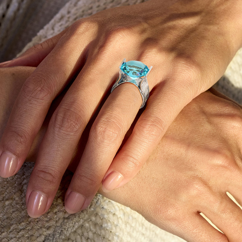 Sterling silver simulated blue topaz ring on finger with sky-blue gemstone
