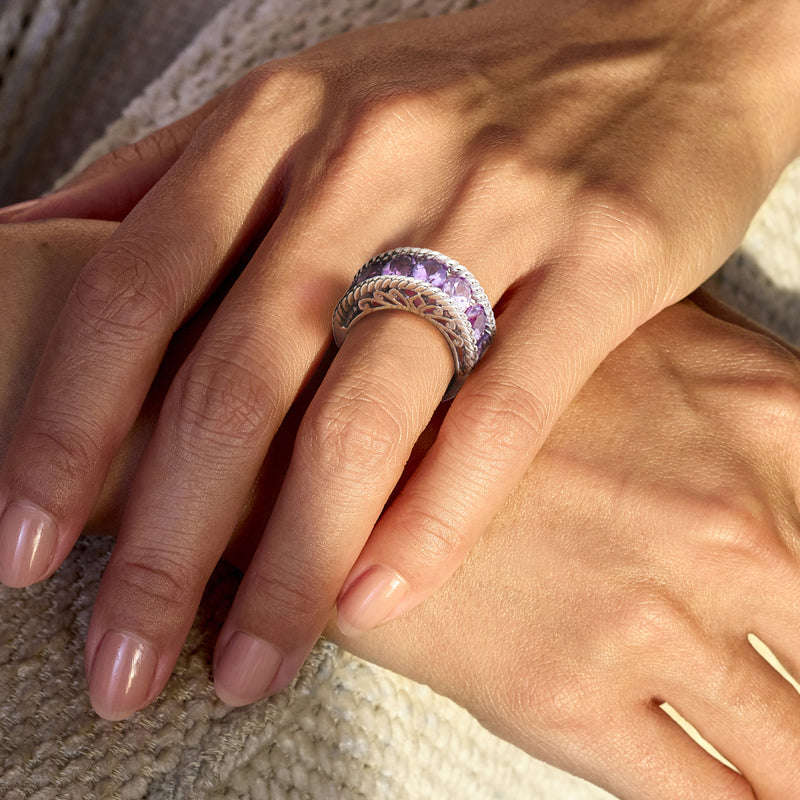 Sterling silver amethyst ring on hand with cushion-cut stones and braided band
