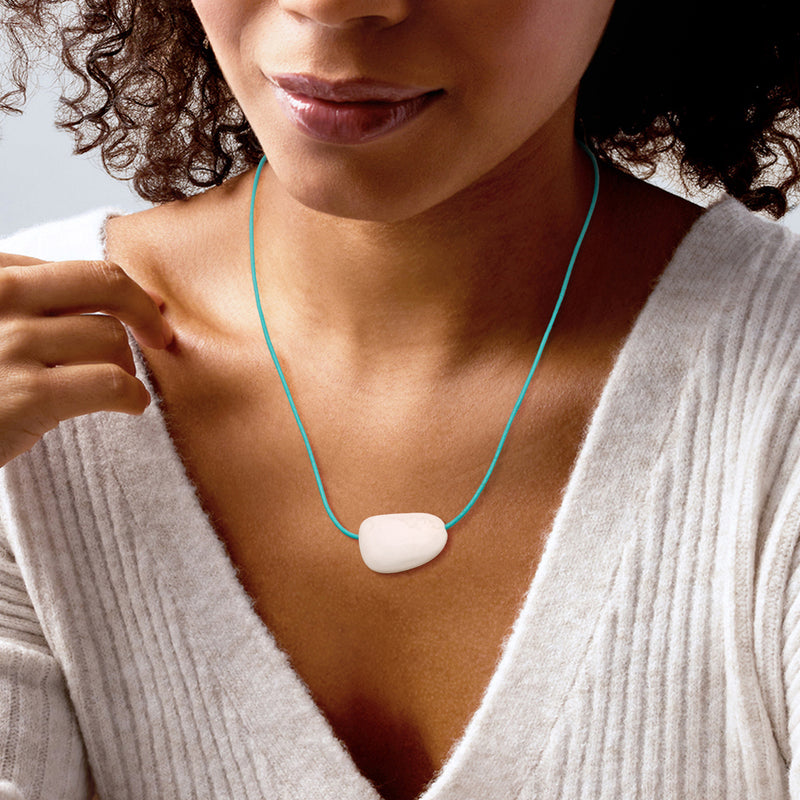 White quartz pendant necklace on blue leather cord, worn with V-neck top