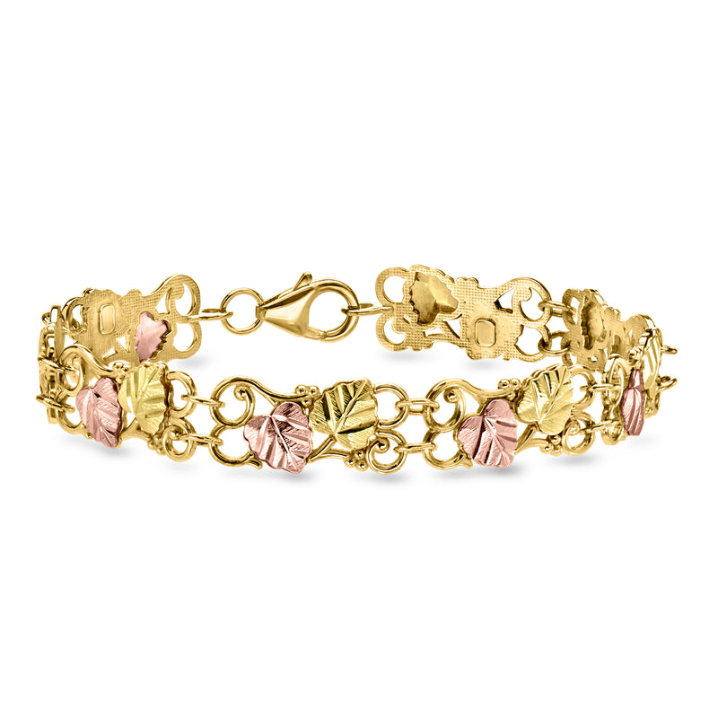 Vintage two-tone gold leaf bracelet with pink gemstone accents and ornate links