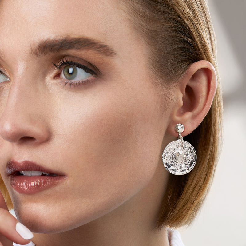 Model wearing sterling silver sombrero drop earrings with engraved round medallions
