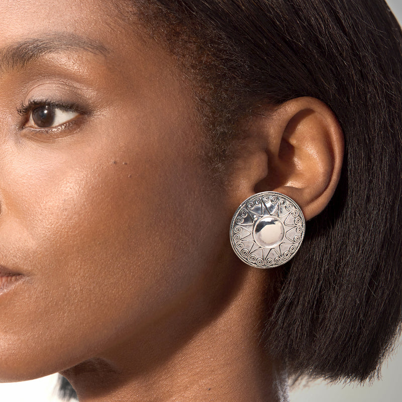 Sterling silver engraved sun disc post earrings on ear, circular design