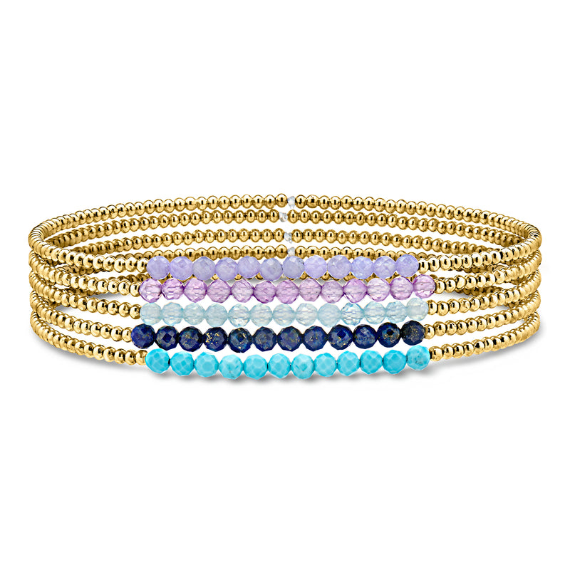 Five gold-tone beaded stretch bracelets with purple, dark blue and teal gemstone beads