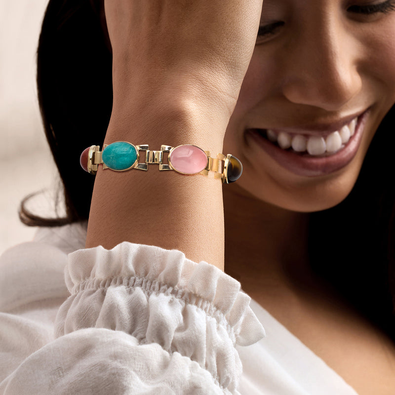 9kt yellow gold link bracelet on wrist with turquoise and pink oval cabochon gems