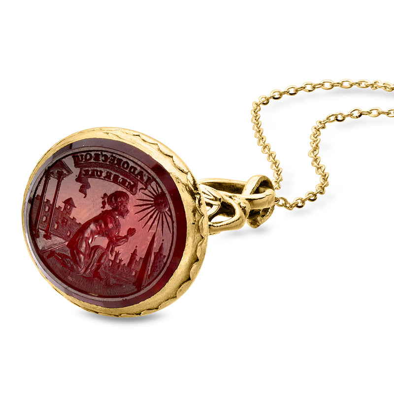 18k yellow gold circular pendant with deep red carnelian intaglio relief