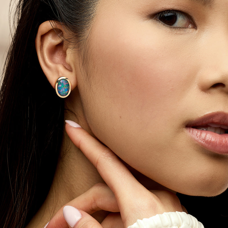 14kt yellow gold oval opal mosaic stud earring on model's ear, iridescent