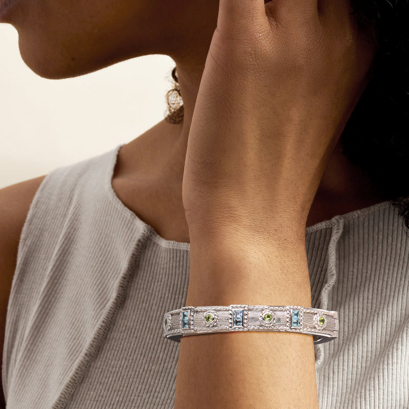 Sterling silver gemstone cuff bracelet on wrist with blue and green stones, openable fit