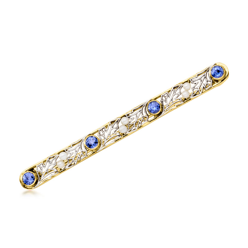 Vintage bar pin with three round blue gemstones in gold-toned filigree setting.