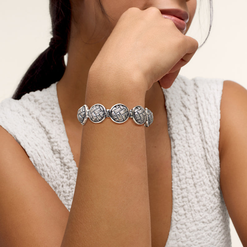 Sterling silver basketweave-link bracelet worn on wrist, round textured links