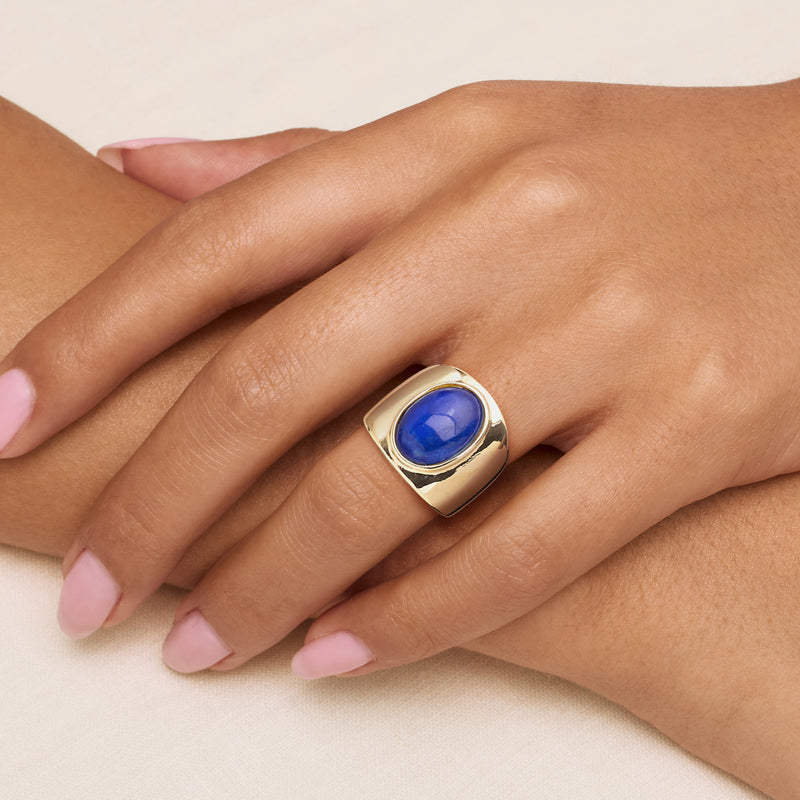 Yellow gold-plated ring with oval simulated lapis on finger, wide band