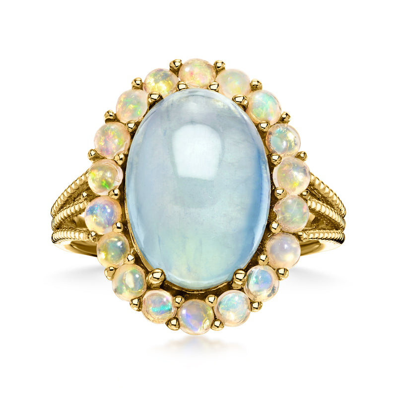 Oval light blue gemstone ring with opal-like stones in gold-tone setting