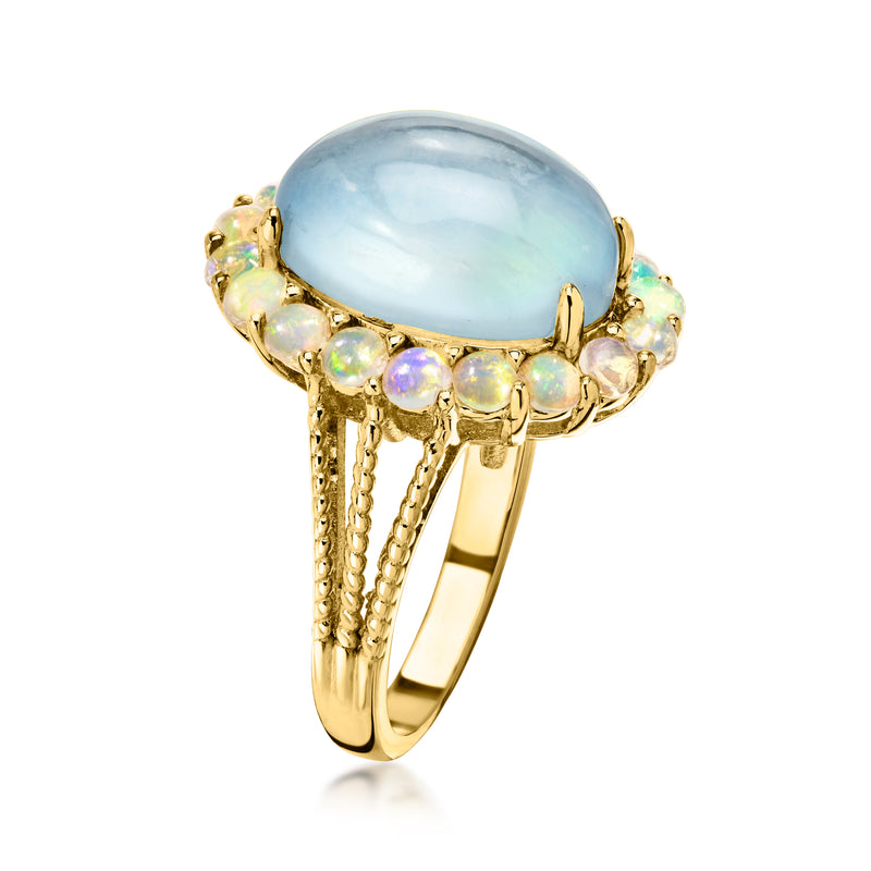 Pale blue oval center stone ring with opalescent side stones and gold band
