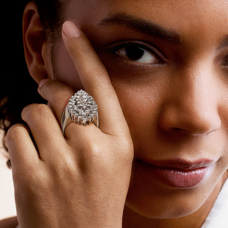 Yellow gold diamond cluster ring on finger, view from above and side