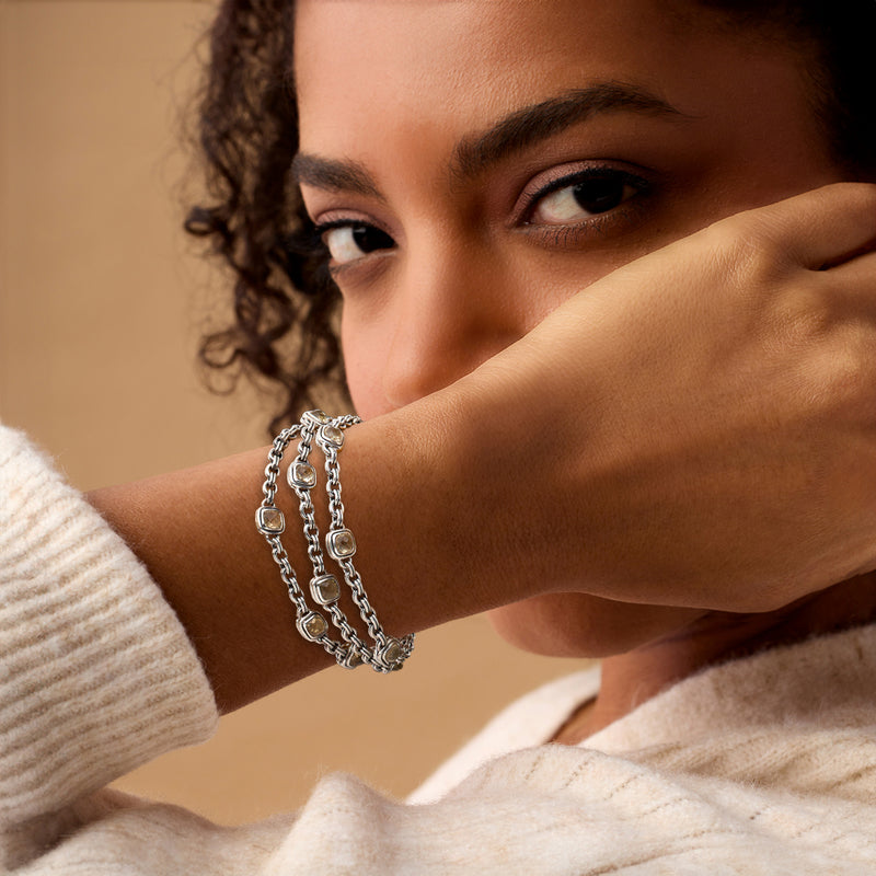 Sterling silver chain bracelet with small yellow square gemstone accents on wrist