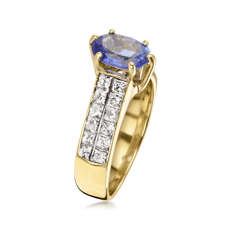 Yellow gold ring with raised oval blue gemstone and diamond baguette side settings