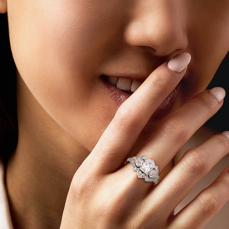 Platinum diamond ring on hand, square center with clustered round diamonds