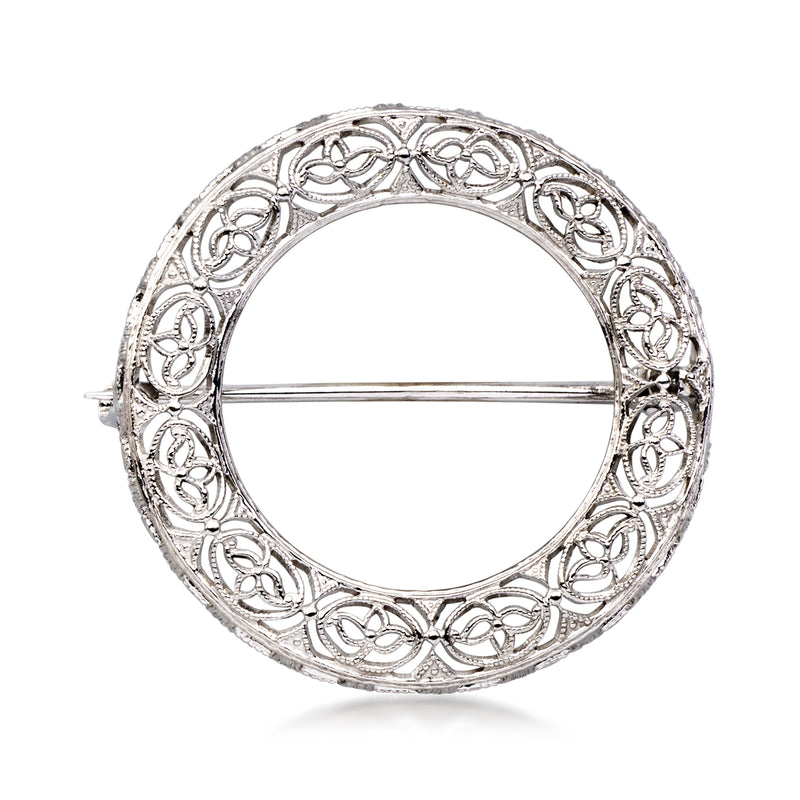 Openwork circular pin with white gold tone filigree design and straight clasp bar