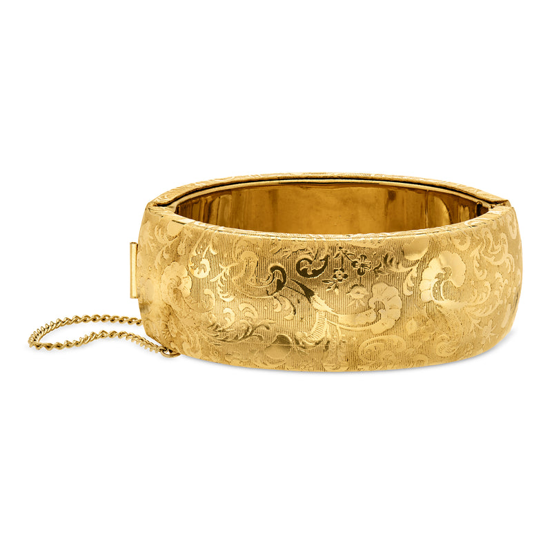Wide gold-tone bangle bracelet with floral etched pattern and vintage etched finish