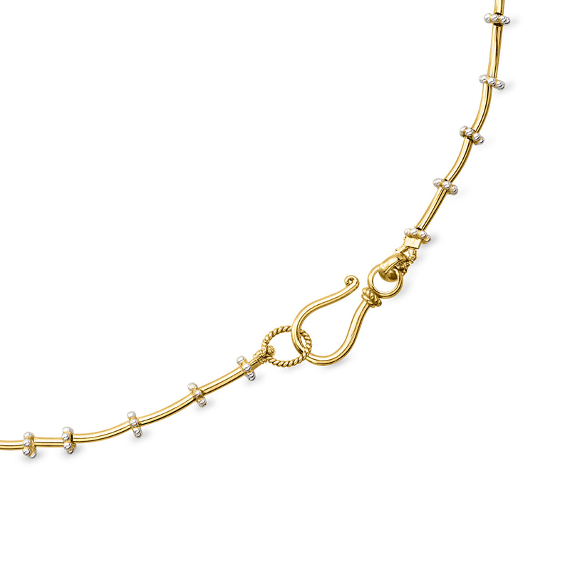 Gold-tone fancy-link necklace with decorative clasp detail and small round link accents
