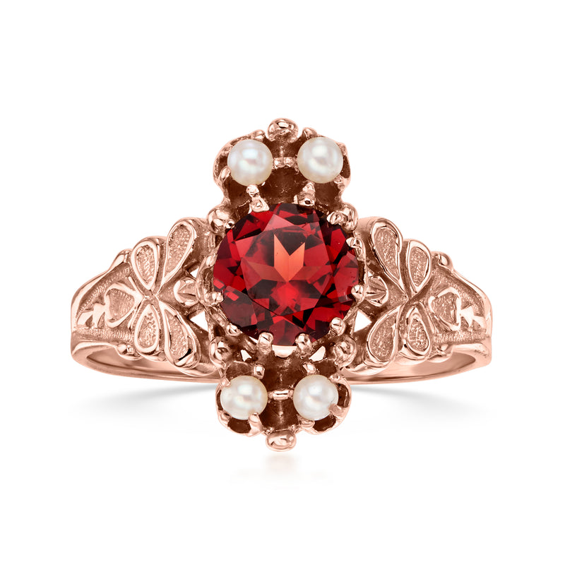 Vintage rose gold garnet ring with red center, pearl clusters, and ornate openwork shoulders