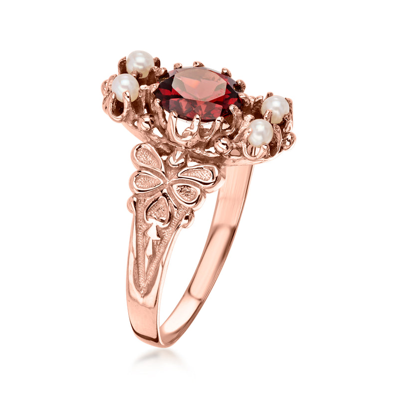 Rose gold vintage garnet ring with floral engraving, red faceted center, and pearl accents