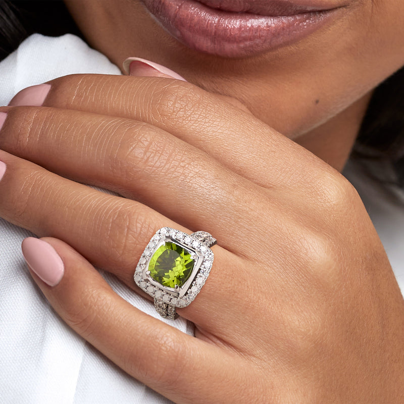 Peridot and diamond halo ring in 14k white gold on hand with square green center stone