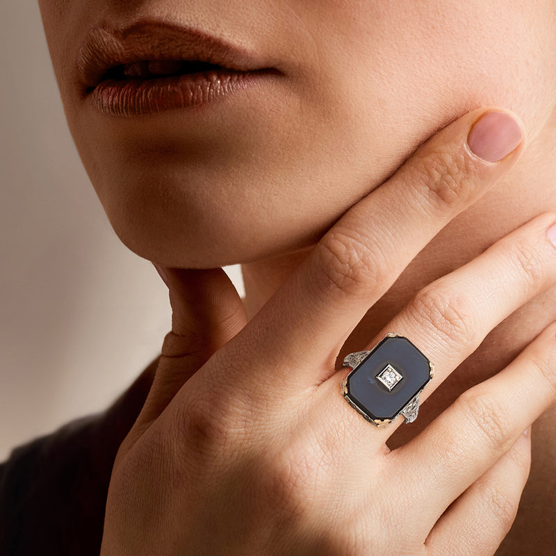 Two-tone gold ring with black square onyx and small square diamond, on hand