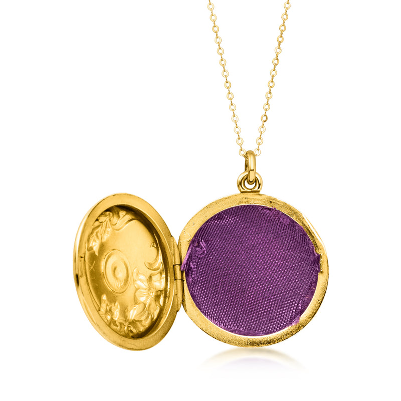 Round gold locket necklace open to reveal purple fabric lining and gold backing