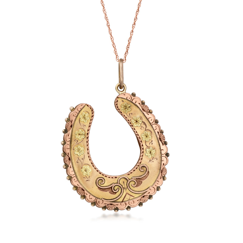 Gold two-tone horseshoe pendant necklace with engraved floral detail and loop bail