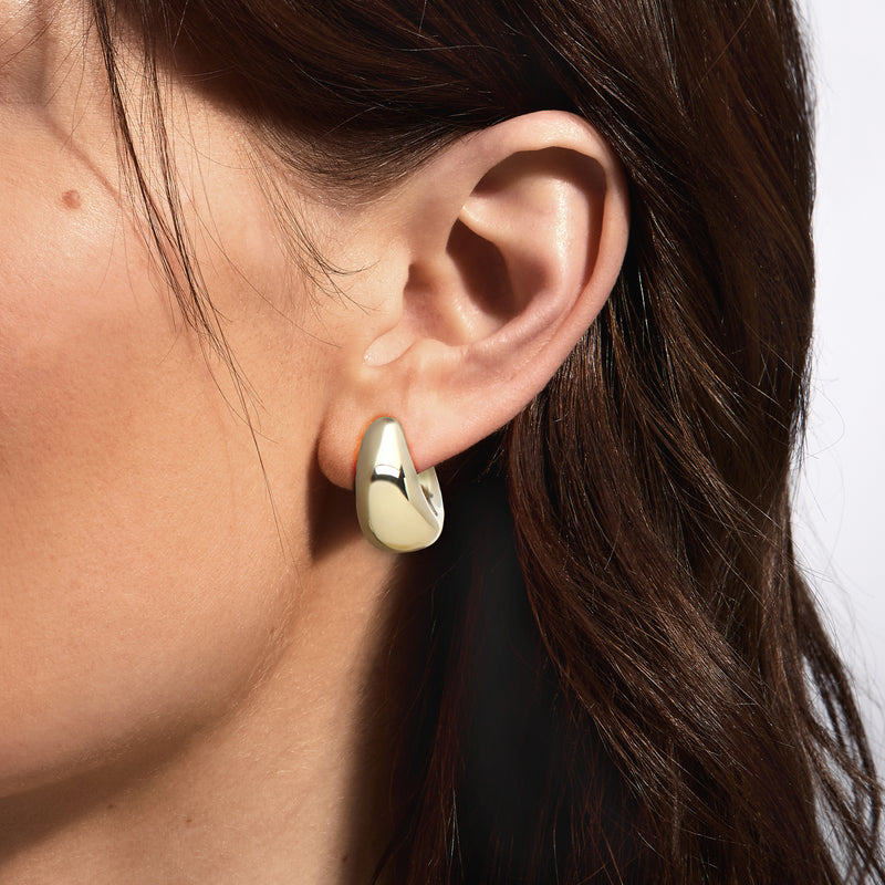 14kt yellow gold puffed hoop earrings on model ear, U-shaped design