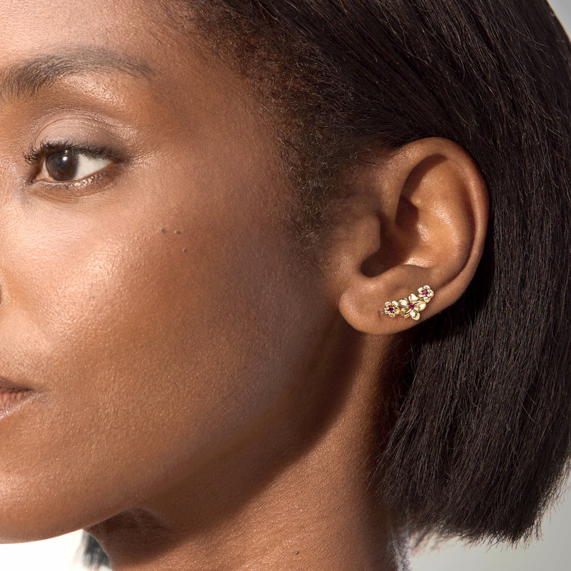 Gold flower ear climber earrings with pink gemstones worn on ear