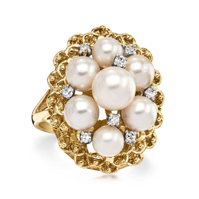 Cultured pearl cluster ring with a large center pearl, small pearls, and diamond highlights.