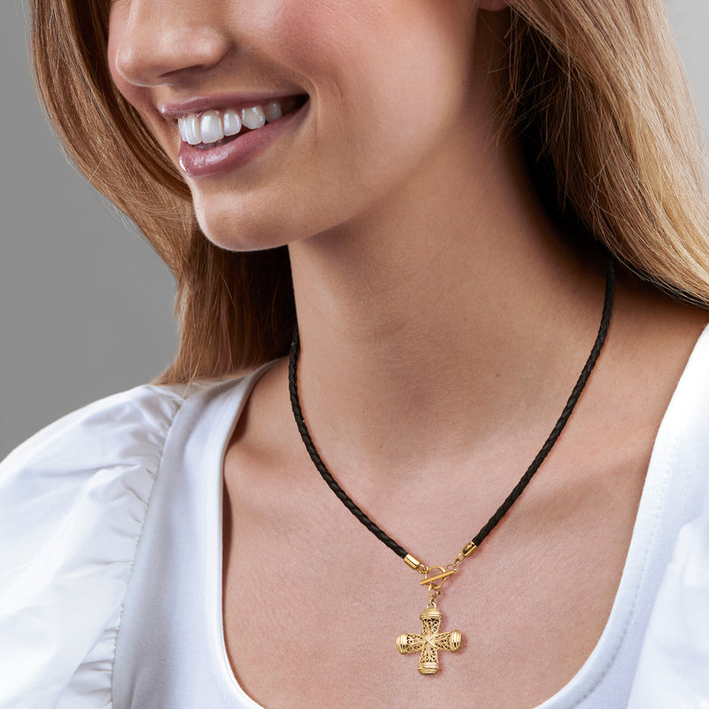 Gold cross pendant on black braided leather cord with filigree detail