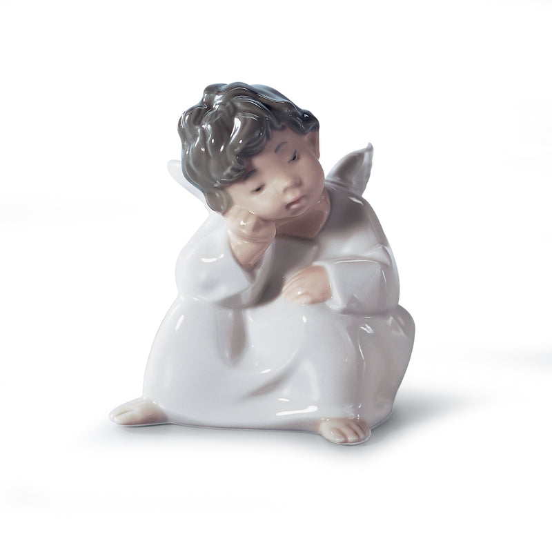 White porcelain cherub angel figurine seated with hands near the face, eyes closed