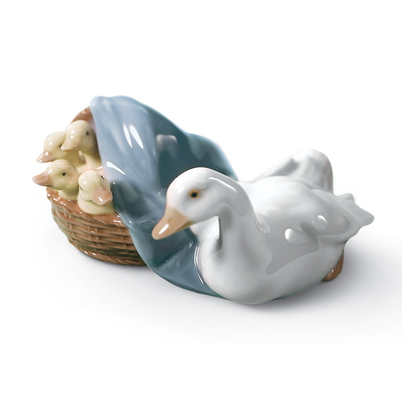 Porcelain duck figurine with two white ducks, one in a blue draped basket