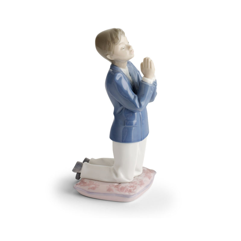 Lladro porcelain figurine of praying boy in blue coat, white pants, on pink base