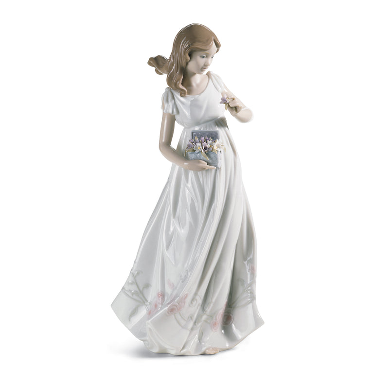 Lladro porcelain figurine of a girl in long white dress, holding small basket and bouquet