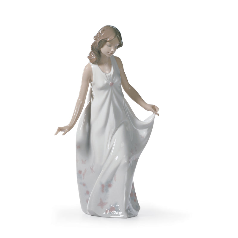 Lladro porcelain figurine of a woman in white flowing dress, holding fabric drape.