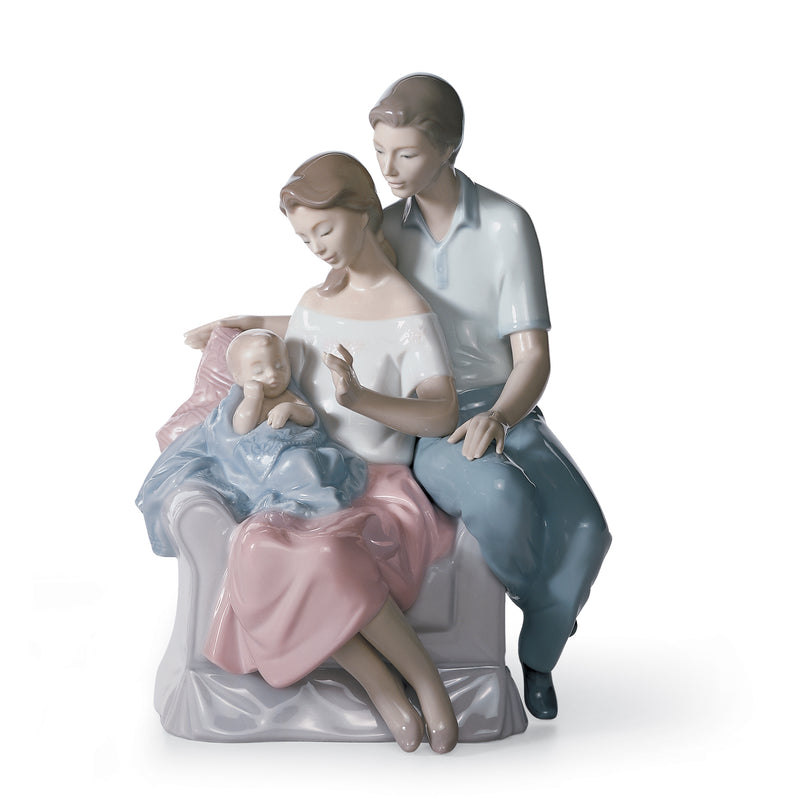 Porcelain figurine of seated woman holding baby with kneeling man beside her