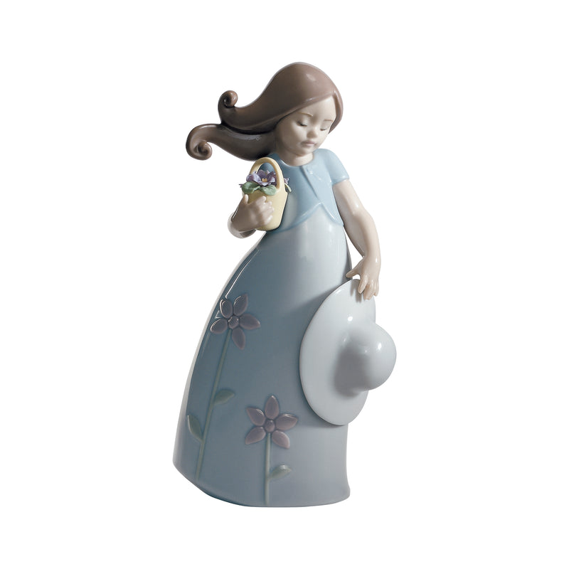 Porcelain figurine of a girl in a light blue dress holding a small flower bouquet