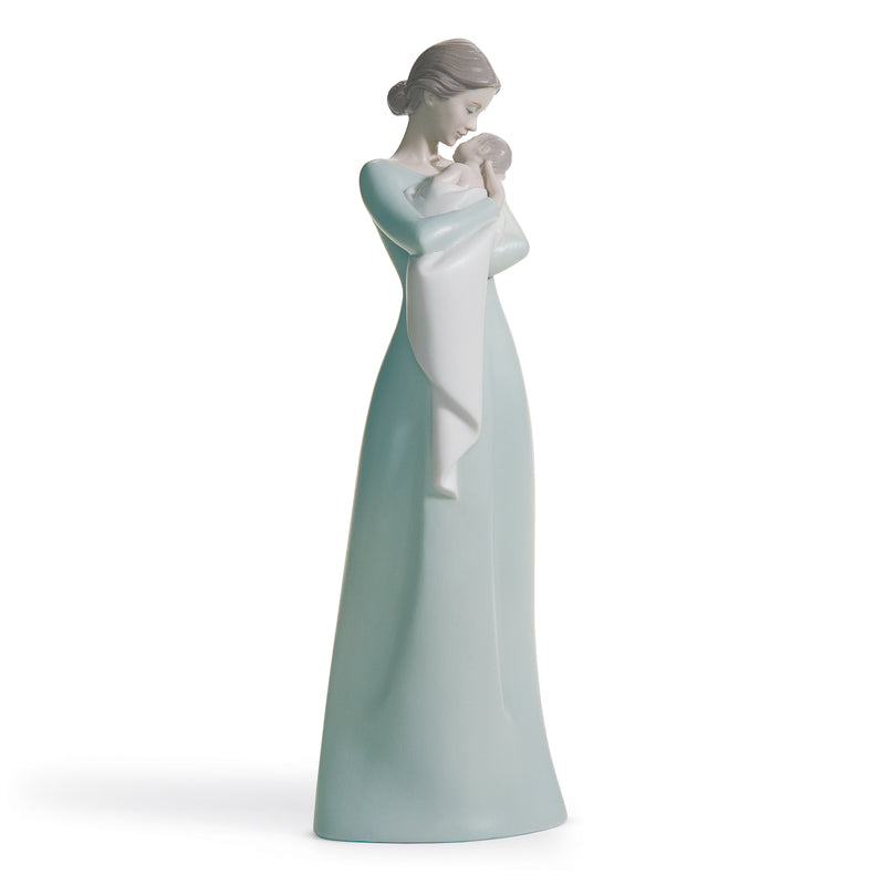 Lladro porcelain mother holding baby figurine, teal and white dress, side view.