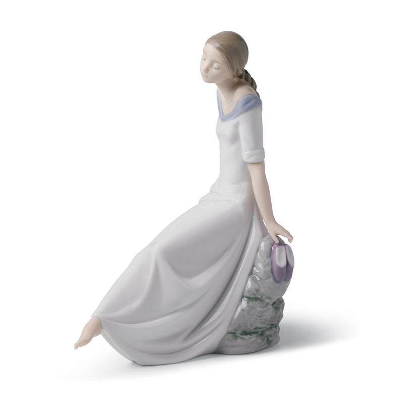 Nao porcelain figurine of a seated woman in a white dress with blue bodice, holding flowers