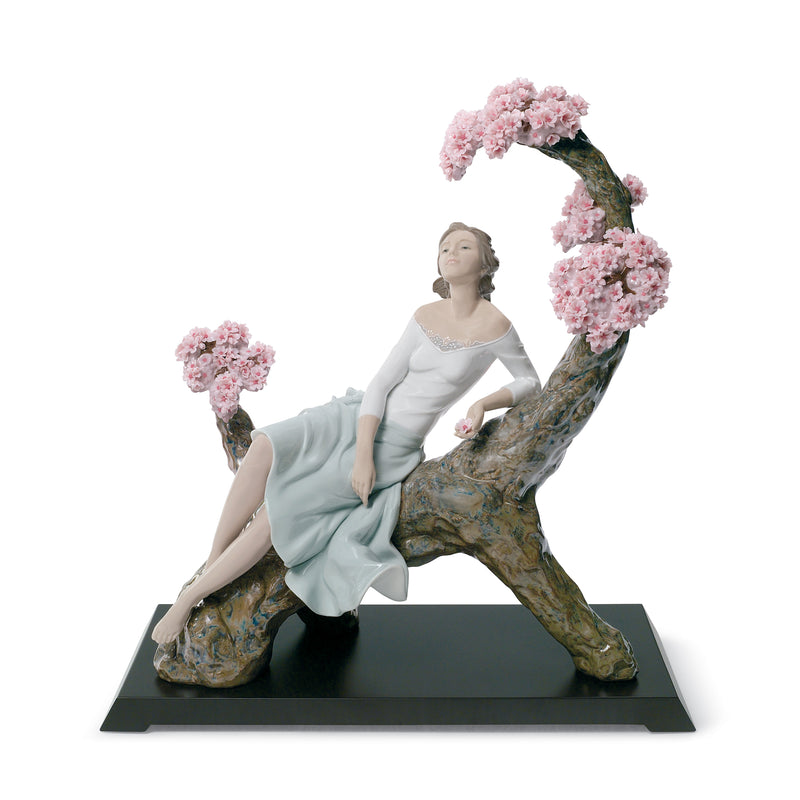 Lladro porcelain figurine of woman in white and light blue holding pink blossoms, on base