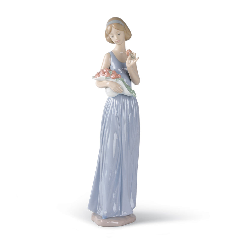 Porcelain figurine of a girl in a blue dress holding a small bouquet