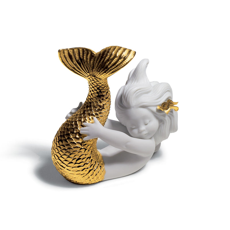 Golden and white porcelain figurine of reclining girl with mermaid tail and shell-like fins